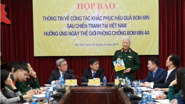 Ông Đào Tuấn (Hội Hỗ trợ khắc phục hậu quả bom mìn Việt Nam) giới thiệu sách “Giáo dục phòng tránh tai nạn bom mìn sau chiến tranh”. Ảnh Nhân dân