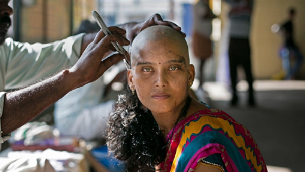 Một phụ nữ đang được cạo đầu hiến tóc