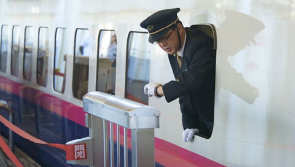 Nhân viên công ty đường sắt JR-Railway căn giờ tàu khởi hành. 