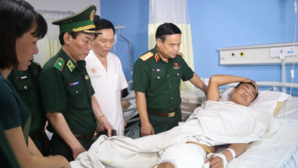 Thượng tướng Lê Chiêm hỏi thăm tình trạng sức khỏe Trung úy QNCN Nguyễn Bình Minh. Ảnh: Thanh Thuận