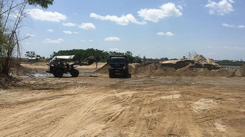 Một bãi tập kết cát khai thác trái phép tấp nập xe tải chở cát đi tiêu thụ.