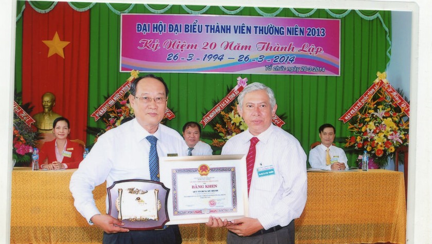 Ông Đỗ Vi Tân - Chủ tịch Hội đồng quản trị Quỹ tín dụng nhân dân Mỹ Thạnh (trái) nhận Bằng khen của UBND tỉnh An Giang