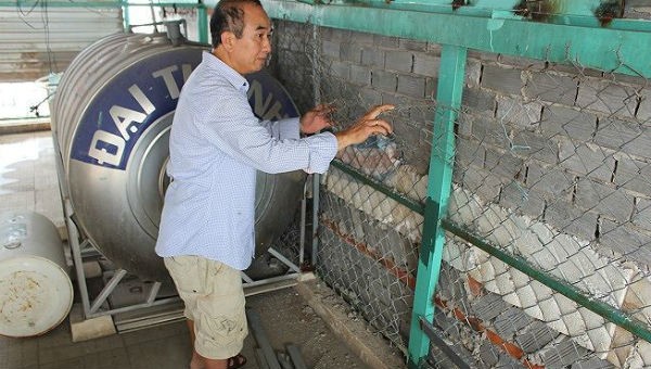 Ông Huỳnh Cường chỉ một số vết cắt lưới B40 bị hư hại trên sân thượng.