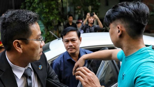 Nguyễn Hữu Linh được che chắn khi vào tòa. Ảnh VnExpress