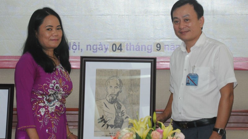 Ông Vũ Mạnh Hà (phải) Giám đốc Bảo tàng Hồ Chí Minh tiếp nhận bức tranh chân dung Bác Hồ từ dịch giả Hiệu Constant.