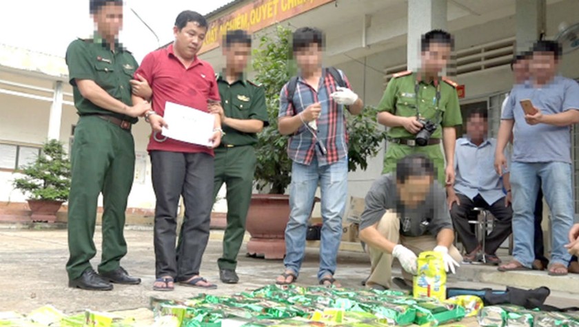 Đối tượng Trương Quốc Cường (thứ hai từ trái sang) cùng tang vật 20 bánh heroin và 57kg ma túy tổng hợp dạng đá ngụy trang trong những bịch trà và túi sữa bột trong Chuyên án 021A