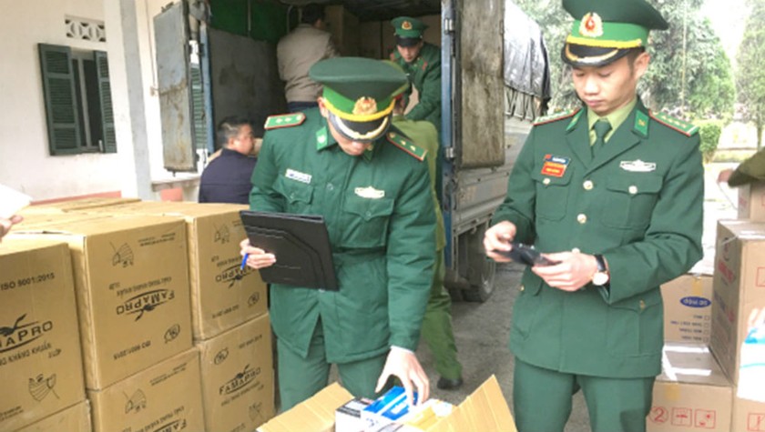 Cán bộ, chiến sỹ Đồn Biên phòng Xín Cái kiểm tra 192.500 khẩu trang y tế đã bắt giữ. Ảnh: Hữu Lanh
