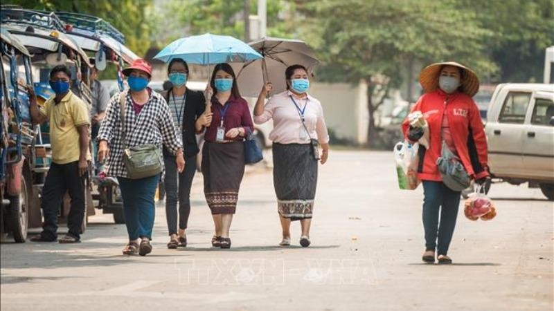 Người dân đeo khẩu trang nhằm ngăn chặn sự lây lan của dịch COVID-19 tại thủ đô Viêng Chăn, Lào ngày 23/3/2020. Ảnh: THX/TTXVN.