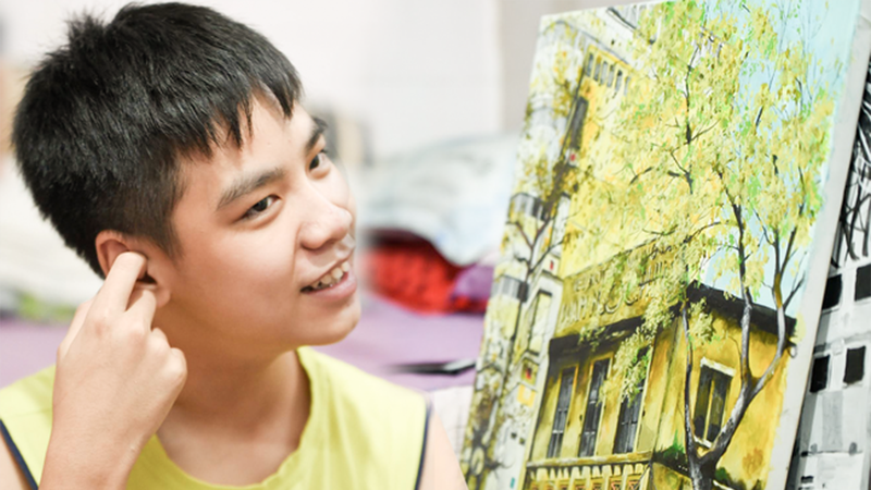 Cậu bé Trần Nam Long và bức tranh tham gia đấu giá.