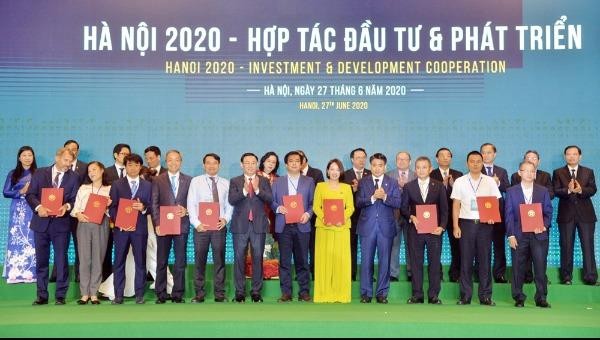 Bí thư Thành ủy Vương Đình Huệ và Chủ tịch UBND thành phố Hà Nội Nguyễn Đức Chung trao quyết định chủ trương đầu tư cho các dự án tại hội nghị “Hà Nội 2020 - Hợp tác đầu tư và phát triển”.