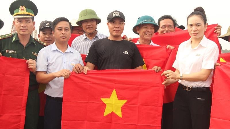 Nhà báo Ngô Văn Toàn  – Trưởng Văn phòng Báo PLVN tại Nghệ An trao cờ cho ngư dân Nghệ An.