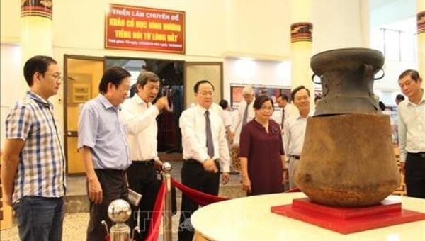 Du khách chiêm ngưỡng Bảo vật quốc gia "Mộ Chum gỗ nắp trống đồng Phú Chánh" trưng bày tại Bảo tàng tỉnh Bình Dương. (Ảnh: TTXVN)