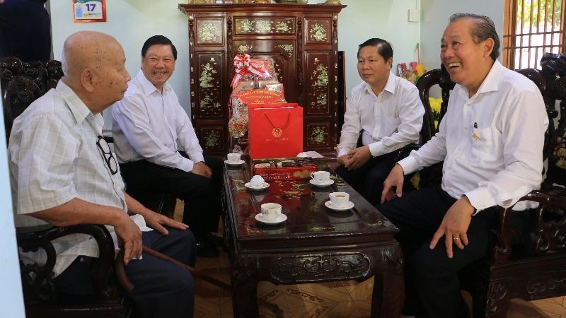 Phó Thủ tướng Thường trực Chính phủ Trương Hòa Bình (bìa phải) và ông Trần Văn Rón, Bí thư Tỉnh ủy Vĩnh Long (thứ 2 từ trái sang) thăm và tặng quà cho gia đình chính sách.