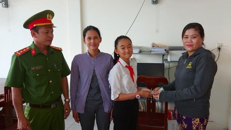Em Nguyễn Thị Như Ý trao trả số tiền gần 14 triệu đồng cho người đánh rơi. Ảnh Nhân dân.