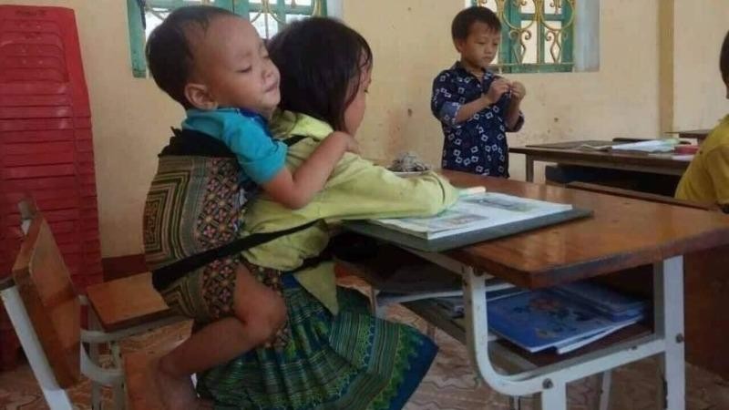 Hình ảnh bé Ninh cõng theo em trai 20 tháng tuổi đi học.