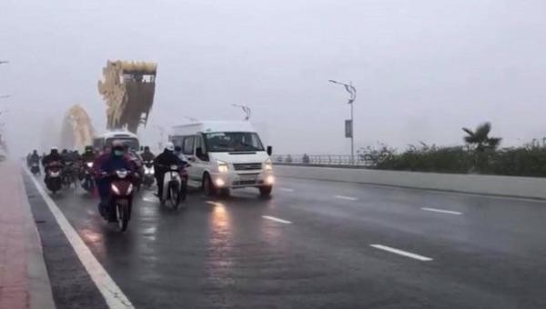 Những chiếc ô tô trên cầu Rồng Đà Nẵng đi chậm lại trong cơn bão, che chở và "dìu" những chiếc xe máy vượt qua mưa gió.