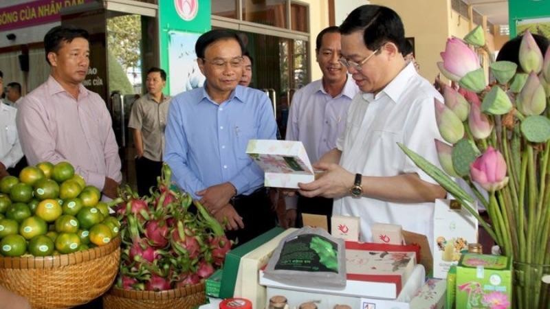 Chủ tịch UBND tỉnh Đồng Tháp Nguyễn Văn Dương giới thiệu các sản phẩm của tỉnh với đồng chí Vương Đình Huệ - Ủy viên Bộ Chính trị, Bí thư Thành uỷ Hà Nội (lúc đó là Phó Thủ tướng Chính phủ).