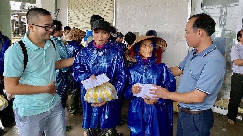 Nhà báo Nguyễn Quang Tám - Trưởng Văn phòng Báo PLVN khu vực Bình Trị Thiên (ngoài cùng bên phải) trao quà cho người dân vùng lũ.
