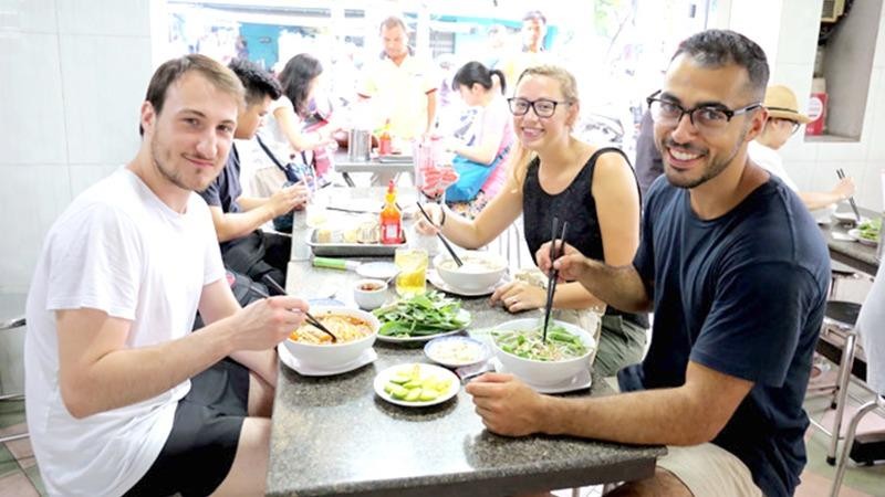 Du khách nước ngoài thưởng thức ẩm thực Việt.
