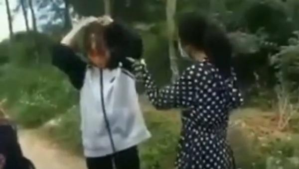 Hình ảnh nữ sinh dùng mũ bảo hiểm đánh bạn. Hình ảnh cắt từ clip.