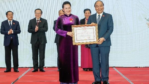 Thủ tướng Nguyễn Xuân Phúc, Chủ tịch Hội đồng Thi đua khen thưởng Trung ương, trao tặng huân chương Đại đoàn kết Dân tộc cho Chủ tịch Quốc hội Nguyễn Thị Kim Ngân.
