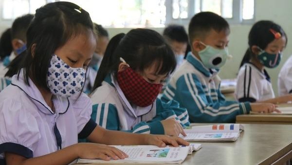 Học sinh Đắk Nông đeo khẩu trang, được kiểm tra thân nhiệt trước khi vào lớp. Ảnh Dân trí