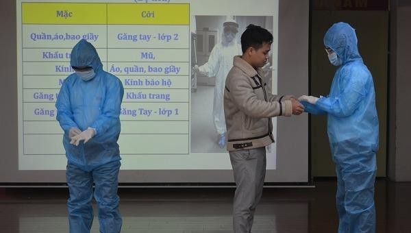 Cán bộ Trung tâm Kiểm soát bệnh tật TP Hà Nội hướng dẫn học viên các thao tác mặc/cởi trang phục bảo hộ đúng cách.