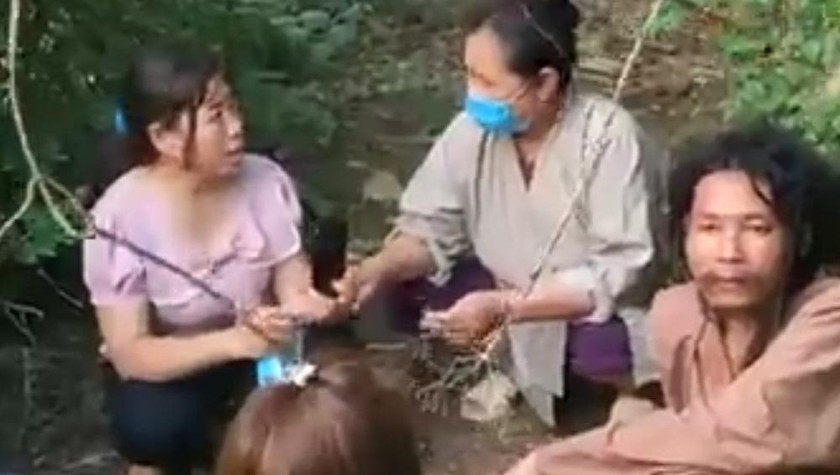 Chị Đinh Thị Cường (áo tím, ngoài cùng bên trái) đang thuyết phục chồng lên xe trở về nhà. 