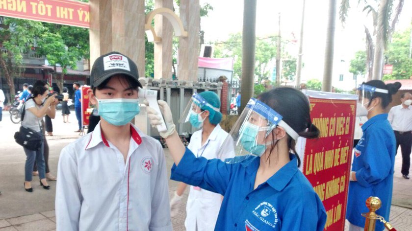 Thí sinh tại điểm thi trường THPT Việt Yên số 1 được đo thân nhiệt trước khi vào điểm thi.