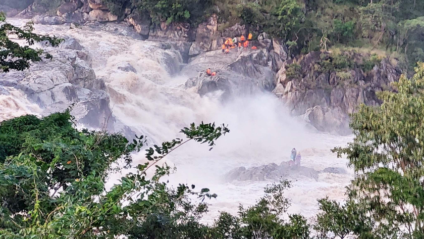 Lực lượng cứu hộ nỗ lực giải cứu 3 người dân mắc kẹt giữa sông.