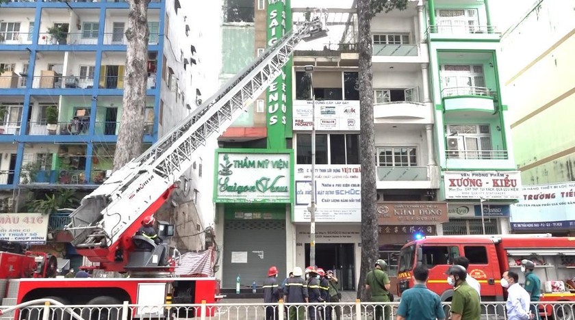Lực lượng chức năng đưa xe thang chuyên dụng để giải cứu 2 người bị mắc kẹt trên sân thượng.