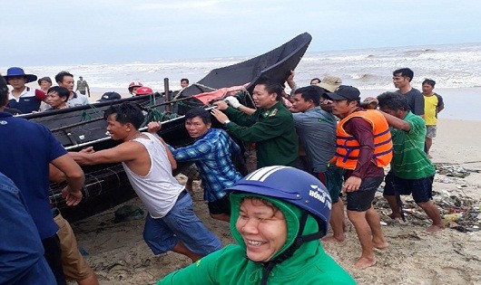 Lực lượng Đồn Biên phòng cửa khẩu cảng Thuận An cùng ngư dân trục vớt chiếu thuyền bị chìm lên bờ.