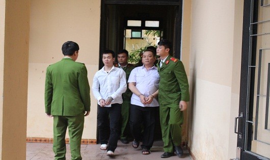 Các bị cáo Nguyễn Huy Quang (áo trắng bên phải) và bị cáo Phan Hoàng được áp giải vào phòng xử án