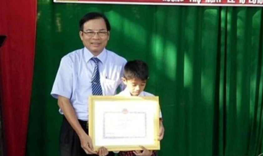 Ông Đặng Phước Mỹ, Phó Giám đốc Sở Giáo dục và Đào tạo tỉnh tặng bằng khen cho em Lê Văn Vũ
