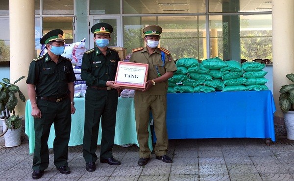 Đại tá Nguyễn Xuân Hòa Chỉ huy trưởng BĐBP tỉnh TT- Huế (đứng giữa) trao tặng vật tư y tế và nhu yếu phẩm cho lực lượng chức năng Lào.