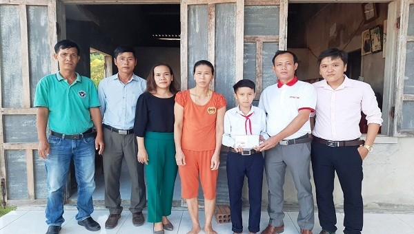 Nhà báo Nguyễn Quang Tám -Trưởng Văn phòng Đại diện báo Pháp Luật Việt Nam khu vực Bình Trị Thiên trao tặng số tiền 5 triệu đồng cho em Võ Văn Đức.