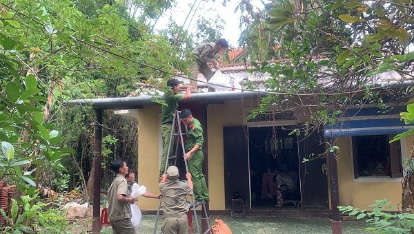 Lực lượng Công an giúp người dân gia cố, giằng chống nhà cửa trước khi bão số 9 đổ bộ.