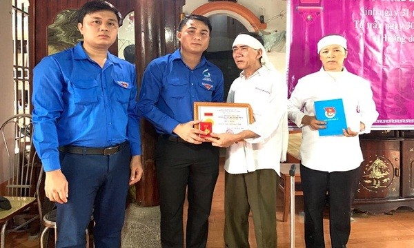Đại diện Tỉnh đoàn Nghệ An thừa ủy quyền Trung ương Đoàn TNCS Hồ Chí Minh truy tặng Huy hiệu Tuổi trẻ dũng cảm cho em Nguyễn Văn Nhã.