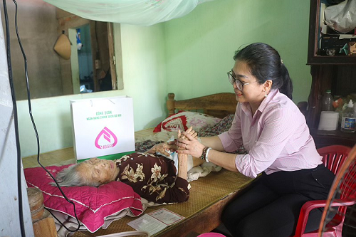 Bà Phạm Hương Giang, Giám đốc NHCSXH tỉnh Thừa Thiên Huế ân cần thăm hỏi sức khỏe và động viên tinh thần các Mẹ Việt Nam Anh hùng Hoàng Thị Khiên.