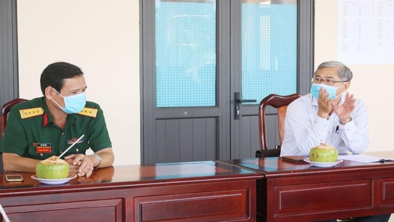 Phó Chủ tịch Thường trực UBND tỉnh Bến Tre Nguyễn Văn Đức (áo trắng) trao đổi tình hình với Thượng tá Nguyễn Văn Cường.