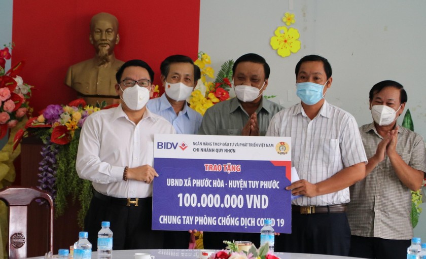Ông Nguyễn Thanh Hồng (trái) trao bảng biểu trưng tặng 100 triệu đồng cho đại diện UBND xã Phước Hòa.