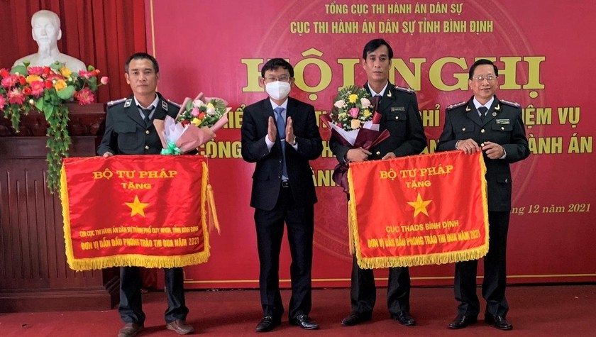 Đại diện Chi cục THADS TP Quy Nhơn (bên trái) nhận Cờ thi đua của Bộ Tư pháp vì đã có thành tích xuất sắc trong phong trào thi đua của ngành Tư pháp năm 2021.