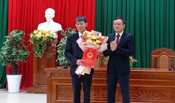 Ông Đào Mỹ (phải) trao quyết định và tặng hoa chúc mừng ông Đặng Văn Trọng.