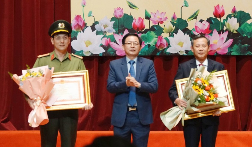 Bí thư Tỉnh ủy Bình Định (giữa) trao Bằng khen của Thủ tướng Chính phủ cho đại diện Công an tỉnh (trái) và Bí thư Thị ủy Hoài Nhơn Phạm Trương.