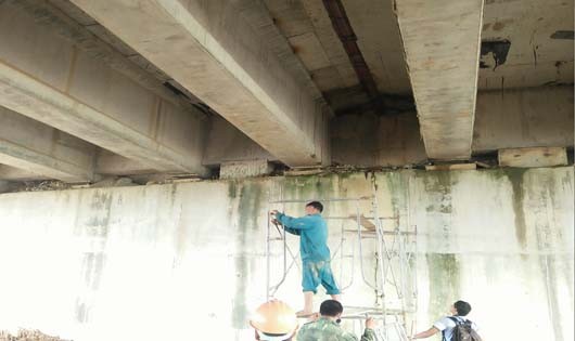 Công nhân sửa chữa thấm nước dưới cầu VD09B