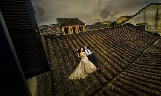 Hình ảnh cặp đôi chụp ảnh cưới trên mái ngói nhà cổ Hội An gây phản cảm.