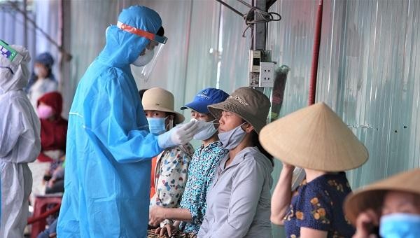 Nhân viên y tế lấy mẫu xét nghiệm COVID-19 cho tiểu thương chợ Siêu thị Đà Nẵng.
