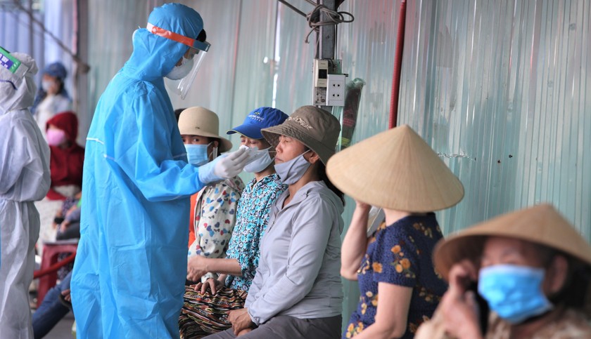 Nhân viên y tế ở Đà Nẵng lấy mẫu xét nghiệm cho các tiểu thương buôn bán ở ch