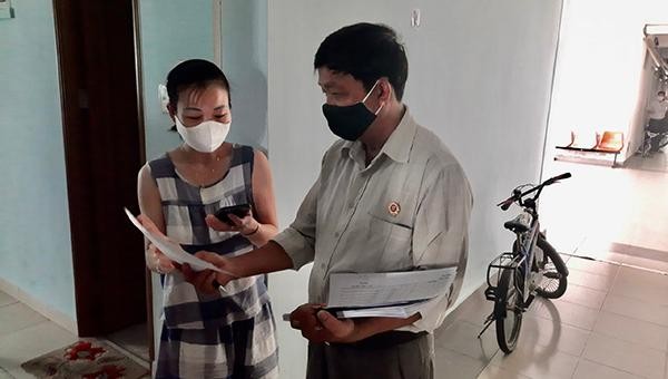 Đại diện UBND phường Nại Hiên Đông, quận Sơn Trà đi phát tiền hỗ trợ cho người dân đang trong vùng cách ly y tế