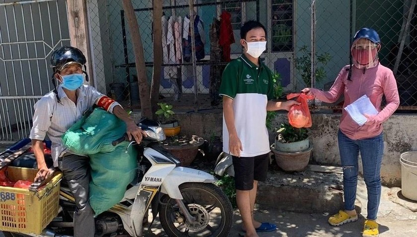 Ông Hứa Văn Tráng (ngồi xe máy) trong 1 lần đi phát thực phẩm hỗ trợ cho người dân.